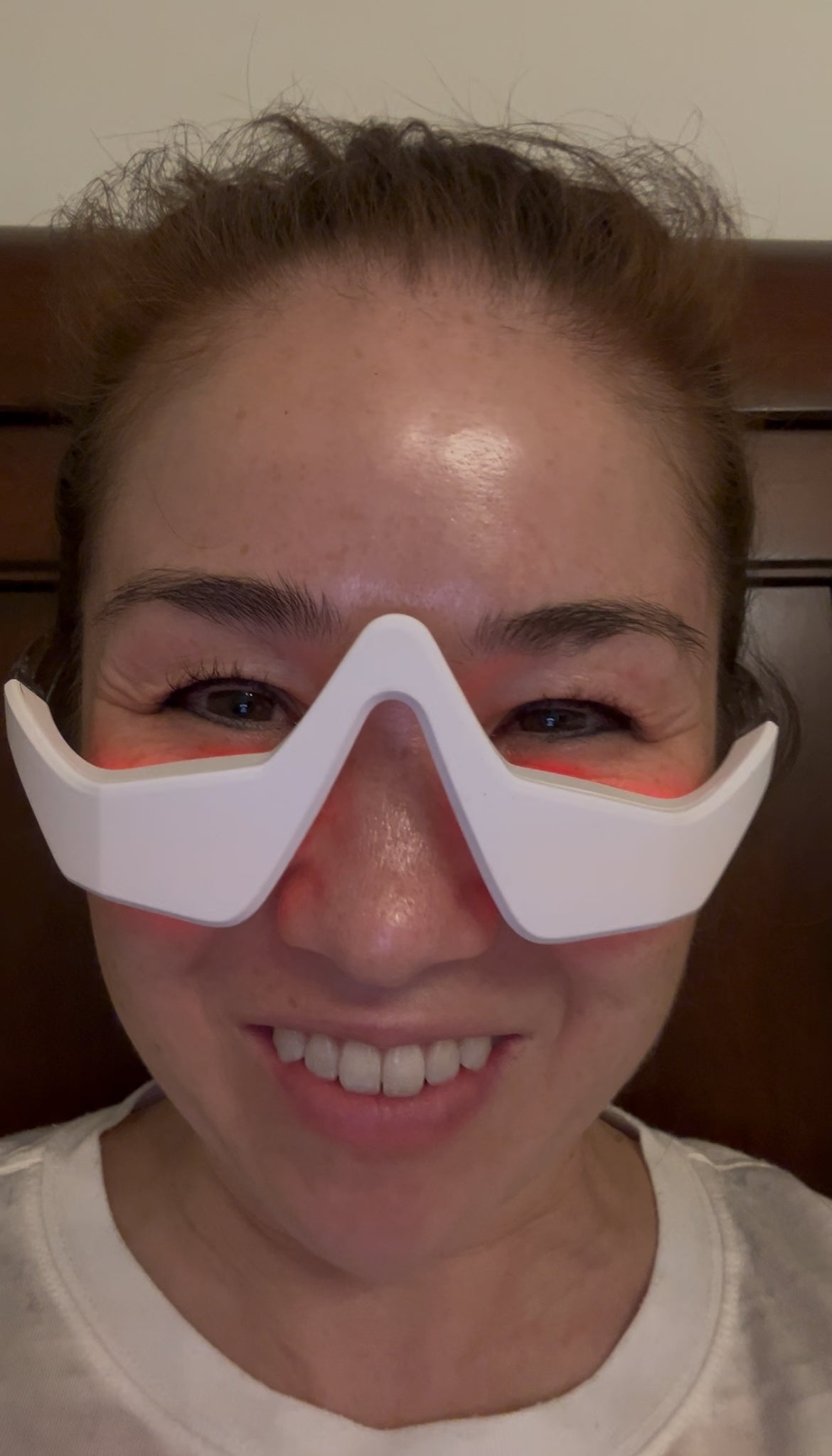 Person wearing a white wavy eye mask against a wooden background.