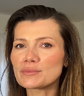 Close-up of a person with long hair against a neutral background