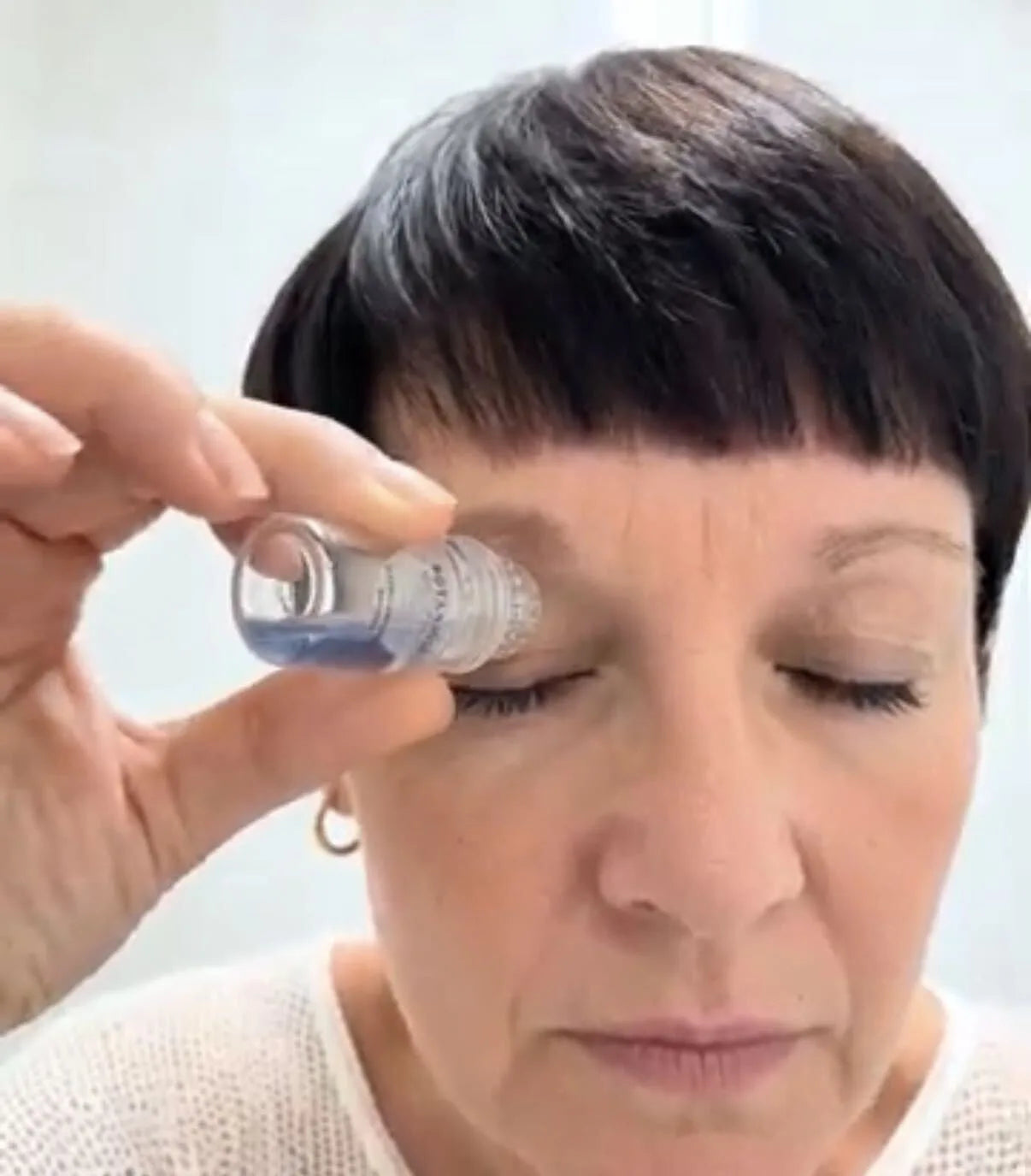 Applicator held to the closed eyelid