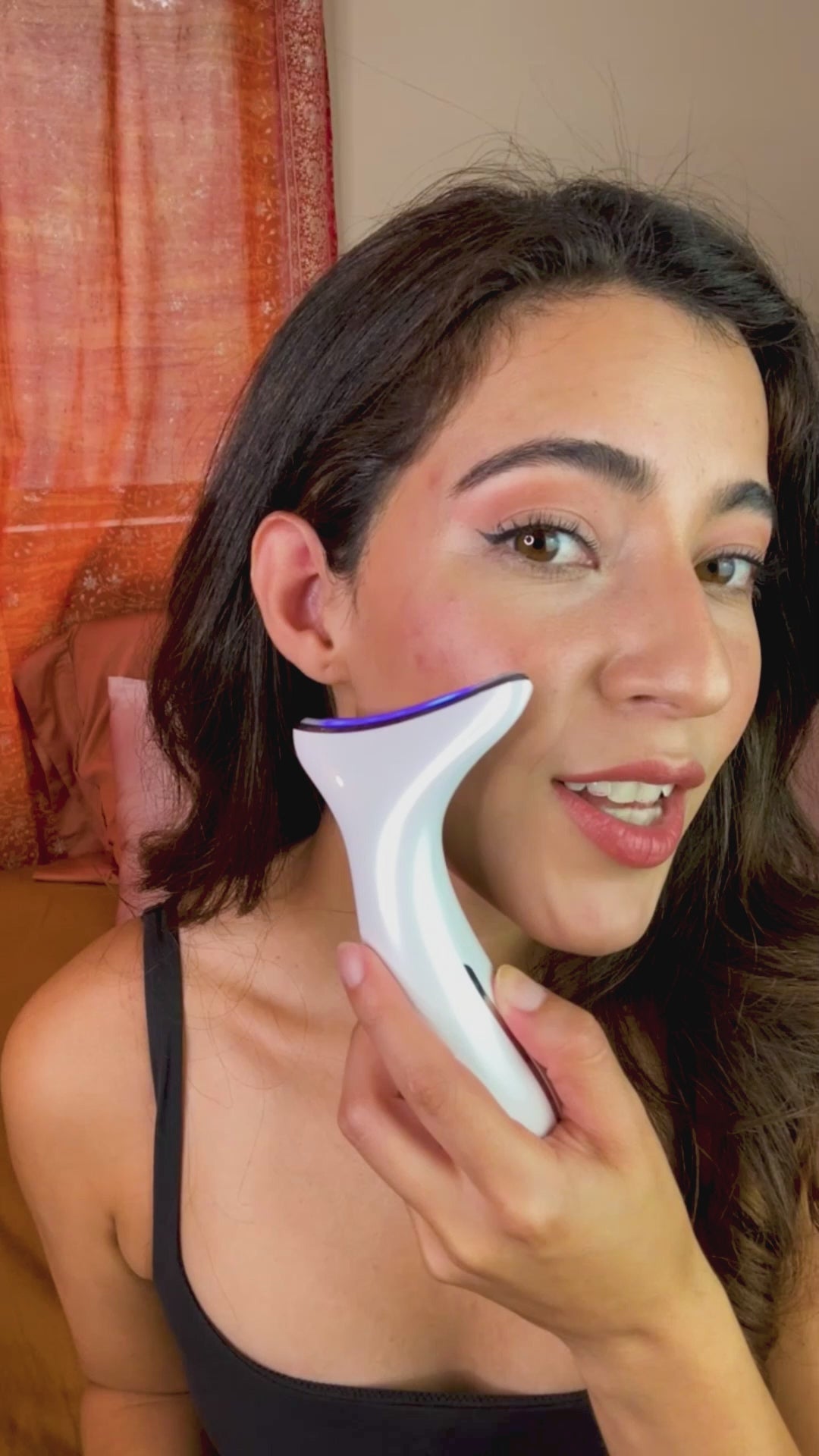 Woman using chin and neck tightening red light therapy device