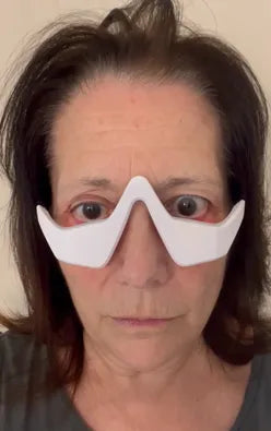Person wearing a RevitalEyes Red Light over their eyes with a plain background
