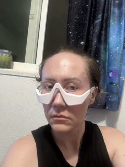 Person wearing a RevitalEyes Red Light over their eyes with a plain background